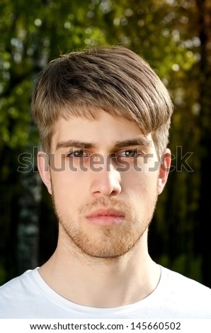 Portrait of young beautiful courageous man in summer garden, a high detailed portrait