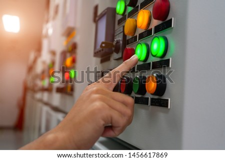 One hand operate on the system control button of colors switch auto system for working at System Control Center room to displaying various information to data analysis in the industry
