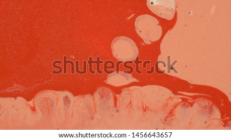 Living coral color liquid paint. Cosmetic glitter texture. Abstract background. Hypnotic mixing and movement of the ink