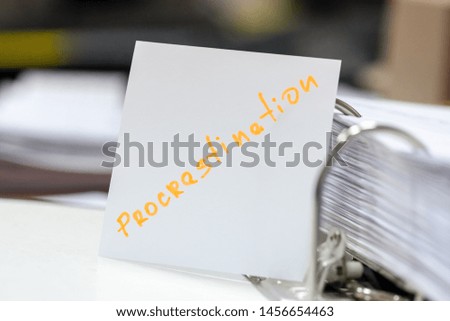 procrastination concept.procrastinating problem. written word at paper note stick. office paperwork stuff around it.