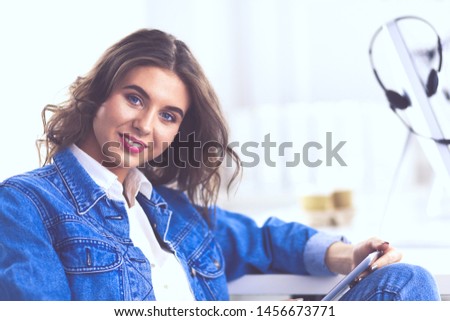 Portrait of beautiful business woman working at her desk with headset and laptop