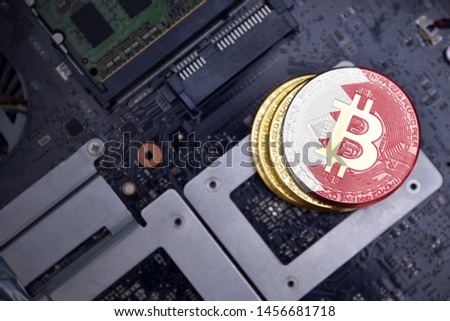 golden shining bitcoins with flag of bahrain on a computer electronic circuit board. bitcoin mining concept.