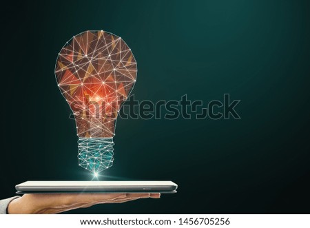 Hand holding smartphone with creative polygonal light bulb on dark background. Innovation, technology and solution concept