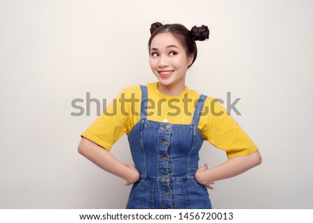 Portrait of beautiful young Asian woman with hair buns and looking flirty at camera on white background