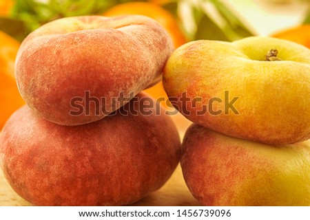 Fresh peaches of their fridge on a wooden table. Selective focus. Chilled fruits. Fig variety. Close up. Summer mood, warm colors.