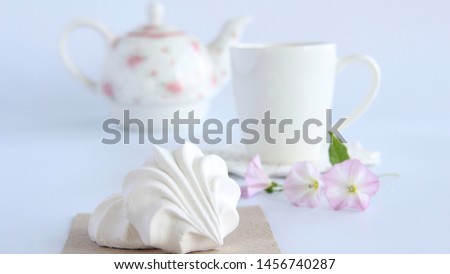 A Cup of tea,marshmallows and a bouquet of wild flowers on a white background.