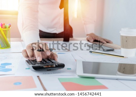 Business is about the use of financial calculators. Tax, financial, revenue, expenses, income, earnings, financial investments, stocks, The graph document is arranged on the table.
