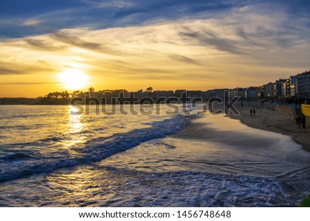 Waves on Silgar beach in Sanxenxo touristic city at golden sunset