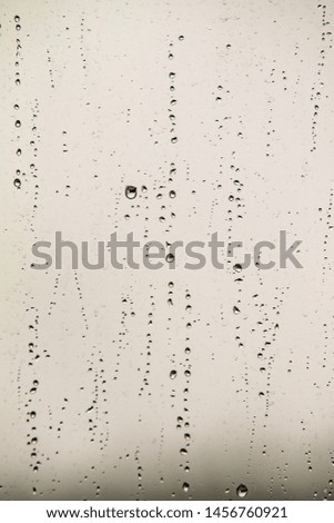 Raindrops on a gray window pane, rain background.