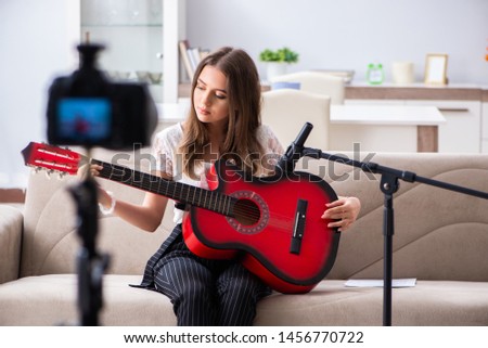 Female beautiful blogger playing guitar 