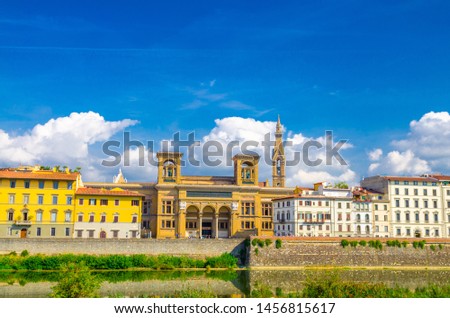 Biblioteca Nazionale Centrale di Firenze National Library and buildings on embankment promenade of Arno river in historical centre of Florence city, blue sky white clouds background, Tuscany, Italy