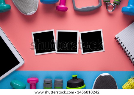 Sport equipment, paper notepad, modern electronic tablet and three picture frame with blank space on pink and blue background