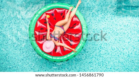 Influencer woman floating with watermelon lilo inside hotel swimming pool - Young girl having fun drinking cocktail and taking sun in summer vacation - Vacation and new trends job concept 
