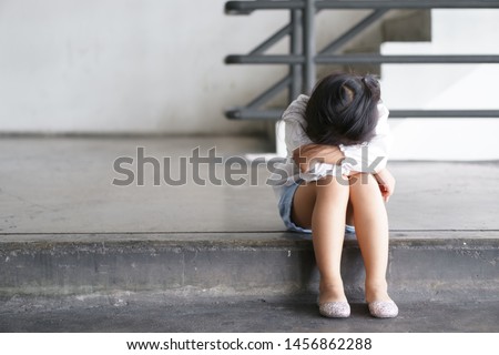Asian child touchy or kid girl sleeping and angry cry with sad or have problems and bend down the head lonely to wait for the parents on city street at nursery or kindergarten and pre school Royalty-Free Stock Photo #1456862288