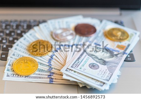 bitcoin, chart and us dollar. Finance trading. Dollar bills laying on a laptop with bitcoin charts on a blurred background