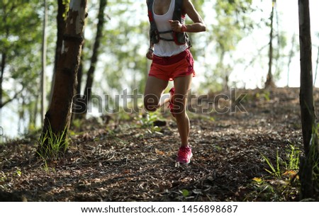 Young fitness woman ultramarathon trail runner running in summer forest  Royalty-Free Stock Photo #1456898687