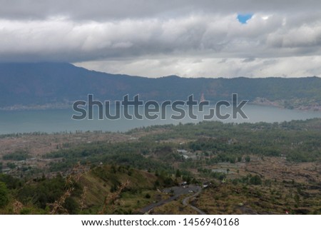 View behind Batur volcano on caldera with lake and opposite Abang mountain. Lake with thermal springs. Natural phenomenon protected by UNESCO. One of the most beautiful volcanic calderas in the world.