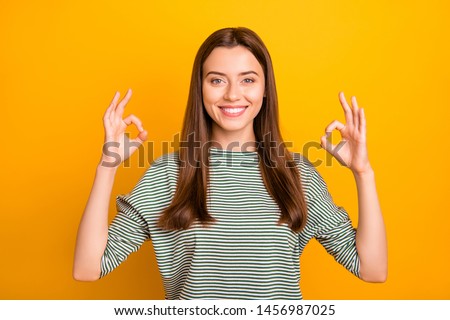 Photo of charming gorgeous woman giving us double okay sign while isolated with yellow background