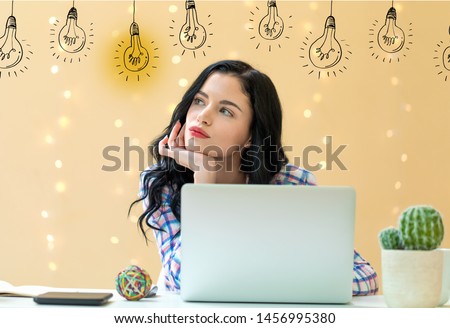 Idea light bulbs with young woman using a laptop