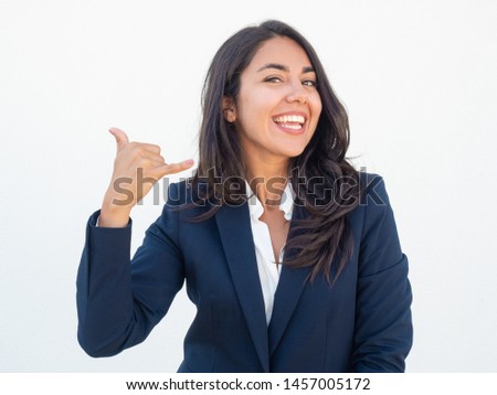 Cheerful manager making telephone gesture. Happy joyful young woman in office suit showing call me sign hands. Phone call gesture concept