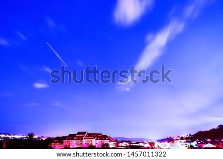 Midsummer  night sky with satellite traces over city.