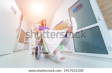 Nurse moves mobile medical chair with patient at hospital. Medical equipment. Concept
