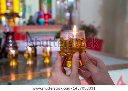 Close up woman hands praying by Candlelight at a Chinese Temple 