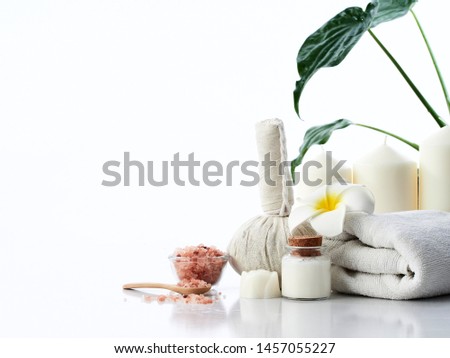 Spa massage concept, herbal compress ball, cream, flower soap, scented candle and Himalayan pink salt, isolated on white