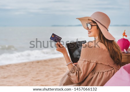 On vacation at Pattaya beach, asian traveler woman with floppy hat use credit card in luxury cafe. Royalty-Free Stock Photo #1457066132
