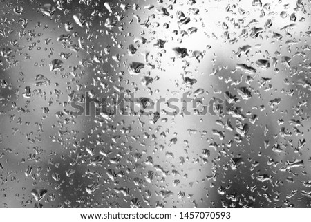 Fresh water drops after raining on blue glass window background in car.