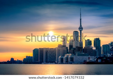 TORONTO CITY SKYLINE AT SUNSET - Beautiful scene of Toronto cityscape with gorgeous sunset sky and clouds. Tight shot of Toronto downtown city buildings with warm sunlight. Toronto, Ontario, Canada