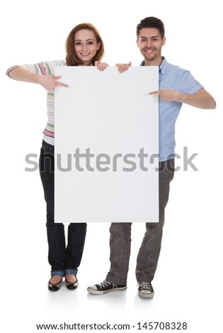 Young Happy Couple Holding Placard Over White Background