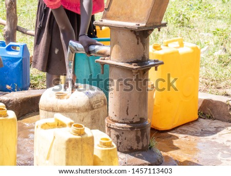 Collecting water in jerry cans borehole Uganda Royalty-Free Stock Photo #1457113403