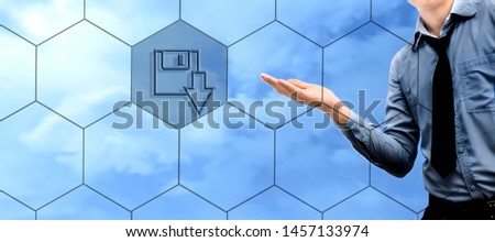 A too-young businessman wearing a blue colored shirt and black tie and holding something in hand without a theme. Isolated on blue colored sky background. With a download now symbol.