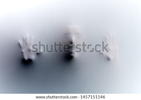man has been left in the room with glass wall.he is trying to get out of the room. guy has been cought by killer. Royalty-Free Stock Photo #1457151146