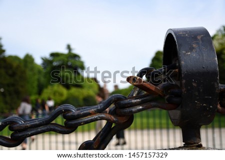 
Milan, Italy, 20.07.2019: Closed Love padlock on a very thick steel chain at Piazza Sempione (Sempione Square) on a sunny, warm day in front of the green, fresh, public Parco Sempione (Sempione Park)