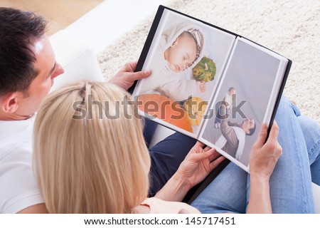 Portrait Of Couple Looking At Photo Album
