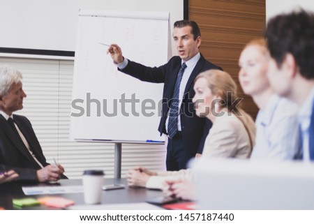 Business man speaking on seminar , whiteboard or flipchart on background