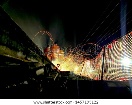 Reconstruction of the railway. workers on the railway cuts rail with a machine. spark light painting while cutting the rail. 