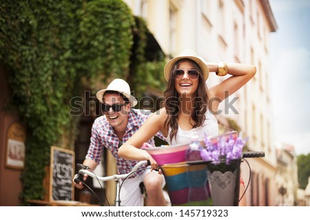 Happy couple chasing each other on bike Royalty-Free Stock Photo #145719323