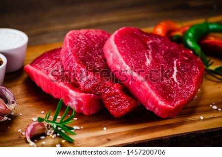 Fresh raw beef steaks on cutting board Royalty-Free Stock Photo #1457200706