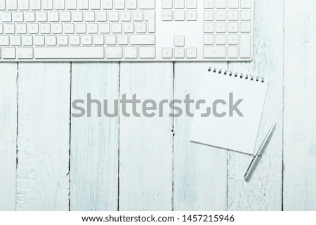 keypad, note pad and metal pen on white wooden table