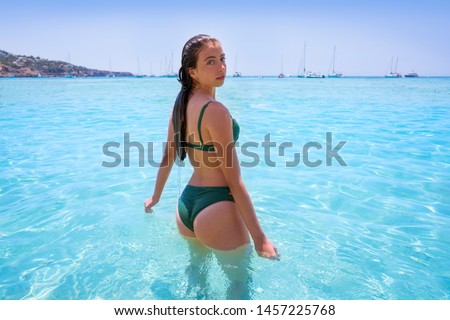 Ibiza bikini girl relaxed in clear water beach of Balearic Islands