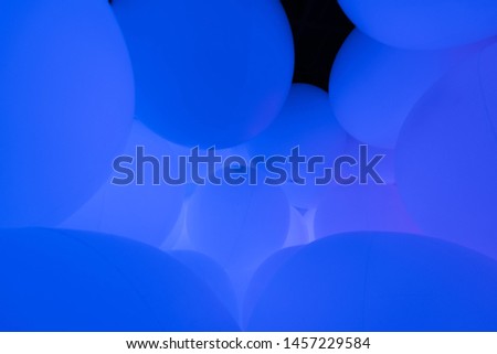 Many blue balloons floating together.