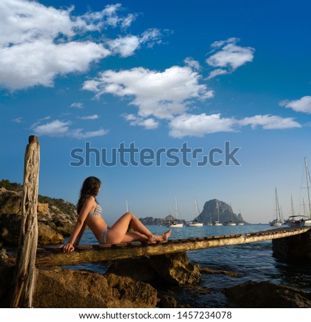 Ibiza cala d Hort girl on pier sunset Es Vedra islet Balearic Islands