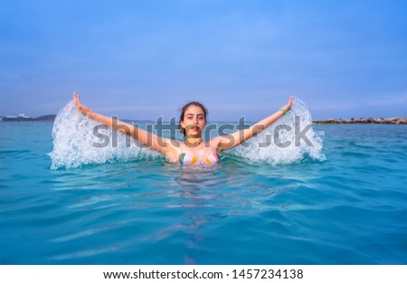 Young woman girl water splash in Ibiza beach of Santa Eulalia at Balearic Islands