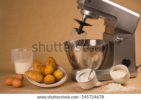 Picture of a mixer and all the ingredients to cook muffins.