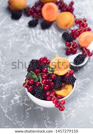 The explosion of different berries. Photo, red currant, black currant, blackberry, apricot on a concrete background. View from above. High resolution product.