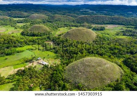 Aerial view of rural farmland and conical limestone karsts in a tropical landscape (Chocolate Hills, Bohol)