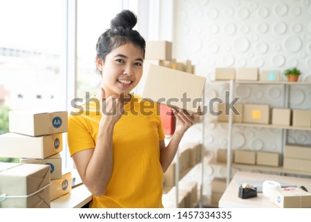 Portrait of Asian freelance woman working at home and start up small business entrepreneur SME with internet online. Young woman is showing hand of like sign.
